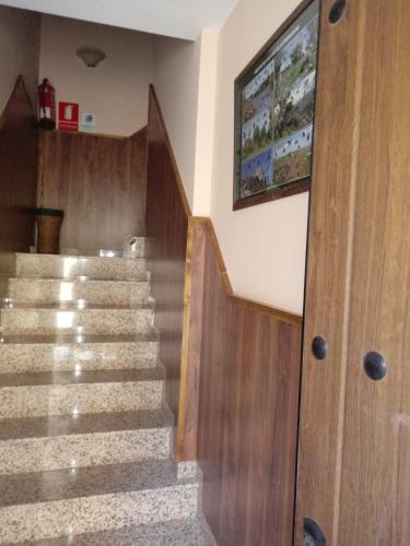a staircase in a house with a tv on the wall at Casa Rural Al-Mofrag y Apartamentos El Mirador de Monfragüe in Villarreal de San Carlos
