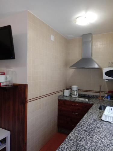 a kitchen with a sink and a stove top oven at Casa Rural Al-Mofrag y Apartamentos El Mirador de Monfragüe in Villarreal de San Carlos