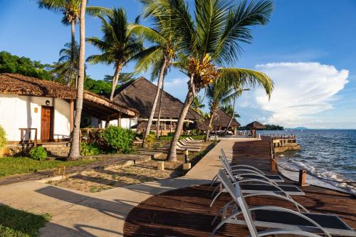 a row of chairs sitting next to the ocean at Corail Noir Hotel in Ambaro