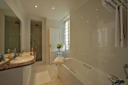 a bathroom with a tub and a sink at Le Manoir Saint Jean in Saint-Paul-dʼEspis