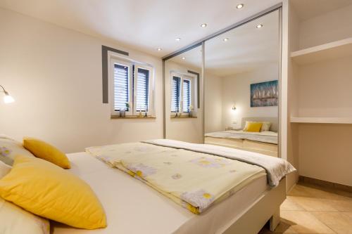 a bedroom with a large bed and a mirror at Ferienwohnungen Velijoze in Poreč