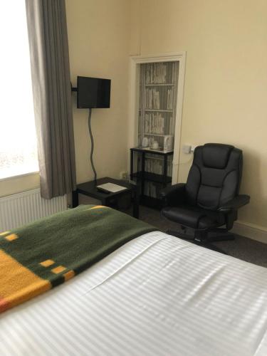 a hotel room with a bed and a chair and a window at The Hunt Lodge in Leighton Buzzard