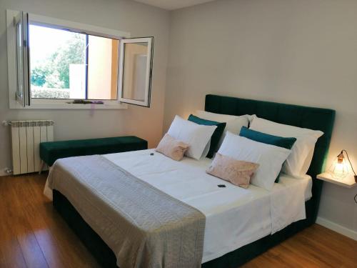 a bedroom with a large white bed with a window at Casa d´Água in Venda Nova
