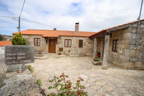 a stone house with a sign in front of it at Casas da Lagariça in Sortelha