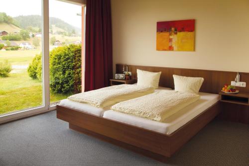 A bed or beds in a room at Vitalhotel Quellengarten - Bed & Breakfast