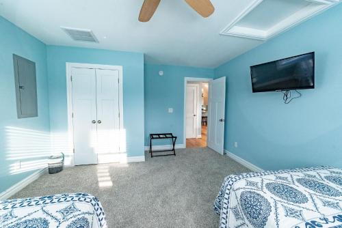 a blue room with a bed and a tv on the wall at Kilmarlic Bubba Watson in Powells Point