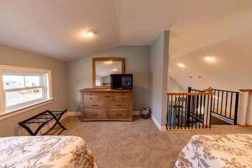 a bedroom with a television and a dresser with a mirror at Kilmarlic Bubba Watson in Powells Point