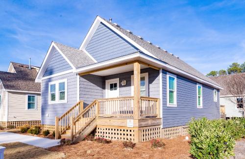 a blue house with a porch and a deck at Kilmarlic Bubba Watson in Powells Point