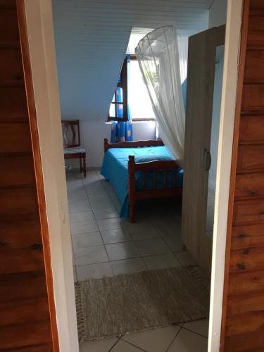 a bedroom with a bed and a window at Chez Ninette près des sources chaudes in Bouillante
