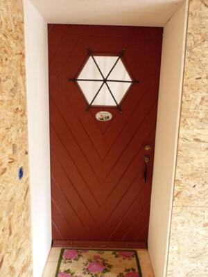 a brown door with a window and a rug in front at Rosenhof in Görisried