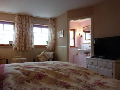 a bedroom with a large bed and a television at Rosenhof in Görisried
