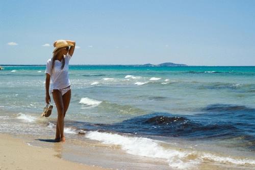 a woman standing on the beach looking at the ocean at Verde Al Mare Boutique Hotel in Kalogria