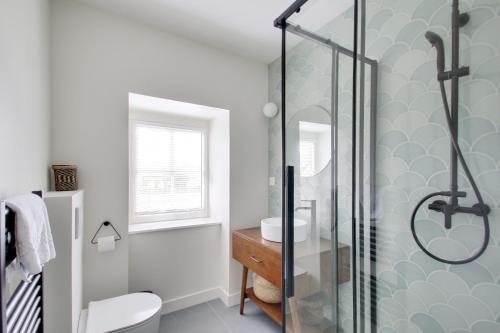 a bathroom with a shower and a toilet and a sink at L'Entre Deux Mers - Belle maison 8 personnes in Dinard