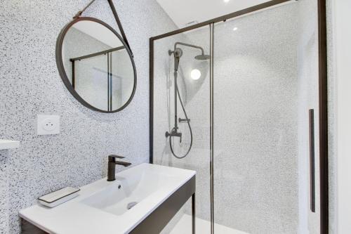 a bathroom with a sink and a shower with a mirror at L'Entre Deux Mers - Belle maison 8 personnes in Dinard
