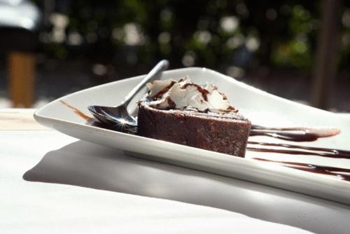 a piece of chocolate cake on a plate with a fork at Verde Al Mare Boutique Hotel in Kalogria