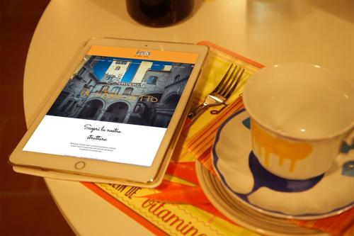 a tablet sitting on a table next to a cup of coffee at Al Libro Letto in Viterbo