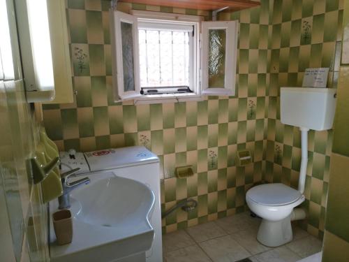 a bathroom with a sink and a toilet and a window at Rodomelo House with Terrace - 4 Bedrooms in Leonidion