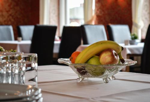 Abild Kro & Hotel في توندر: وعاء زجاجي من الفواكه على طاولة
