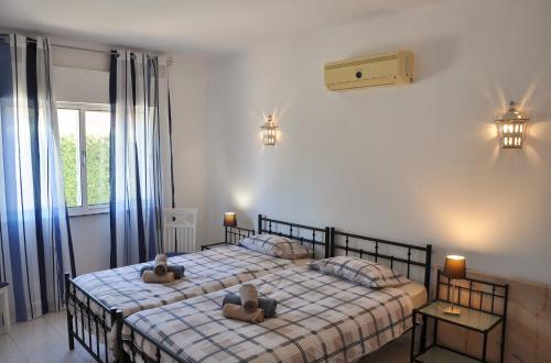 een slaapkamer met een bed met twee kussens erop bij Do Jardim in Carvoeiro