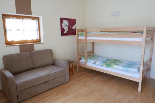 a living room with a couch and bunk beds at Gasthof Pension „Zur Hammerschmiede“ in Drosendorf Altstadt