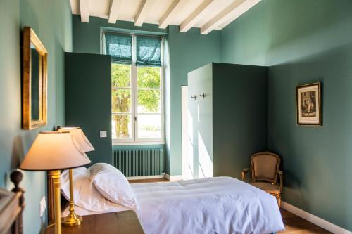 a bedroom with green walls and a bed and a window at Château Sigalas Rabaud in Bommes