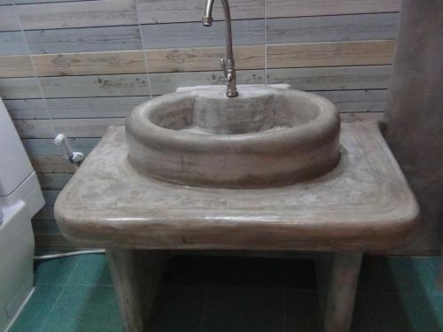 a stone sink with a faucet in a bathroom at Tuaprodhome in Khao Lak