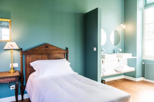 a bedroom with a bed and a bathroom with a sink at Château Sigalas Rabaud in Bommes