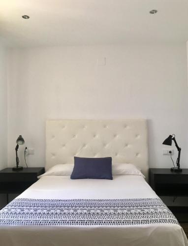 a bedroom with a large bed with a blue pillow at Apartamento La Güixa in Albir