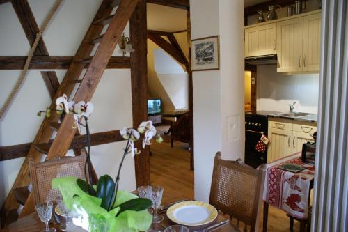 een keuken en eetkamer met een tafel en een ladder bij Gîtes les bains in Riquewihr