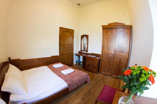 a bedroom with a bed and a table with a vase of flowers at Zamek Golubski in Golub-Dobrzyń