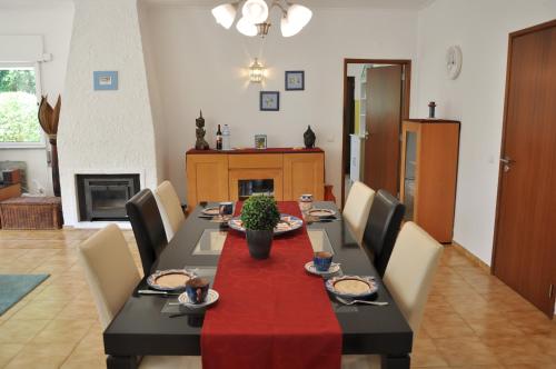 a dining room with a table with a red table cloth at Do Jardim in Carvoeiro