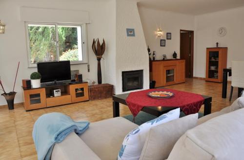 a living room with a couch and a table at Do Jardim in Carvoeiro