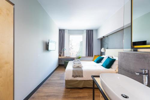 Habitación de hotel con cama y lavabo en St. Bjur Suites, en Atenas