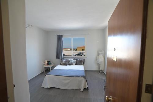 a small bedroom with a bed and a window at STANZINA DELLA BARONESSA in Carini