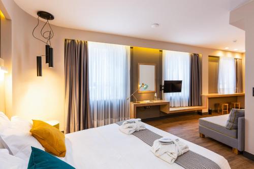 Habitación de hotel con cama y sofá en St. Bjur Suites, en Atenas