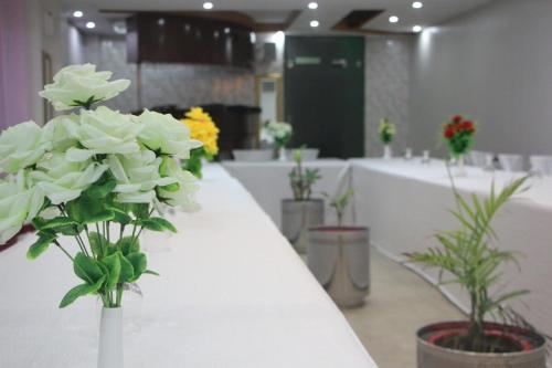 a room with white flowers in vases on a counter at Hotel The Leschanze in Lahore