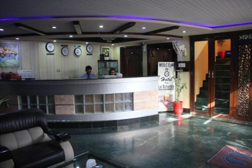 a bar in a restaurant with a man behind the counter at Hotel The Leschanze in Lahore