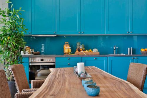 a wooden table in a kitchen with blue cabinets at Landvilla Pia in Attendorf