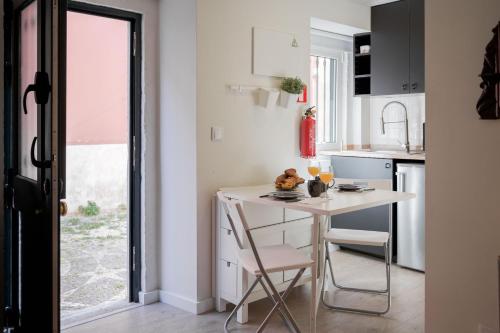 a kitchen with a table and chairs and a window at Typical and Brand New T.M. Flat in Lisbon
