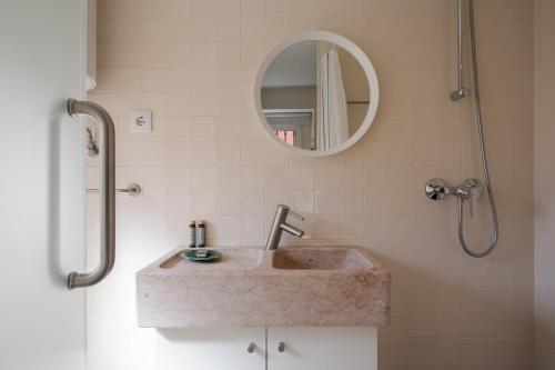 ein Bad mit einem Waschbecken und einem Spiegel in der Unterkunft Typical and Brand New T.M. Flat in Lissabon