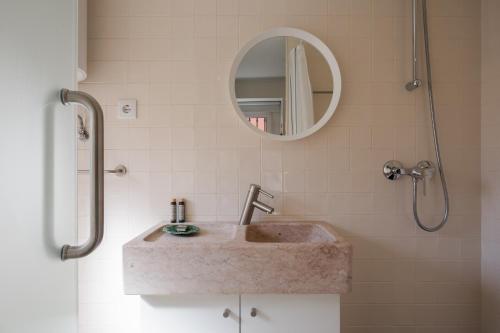 a bathroom with a sink and a mirror at Typical and Brand New T.M. Flat in Lisbon