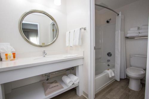 a bathroom with a sink and a toilet and a mirror at Cedar Point Hotel Breakers in Sandusky