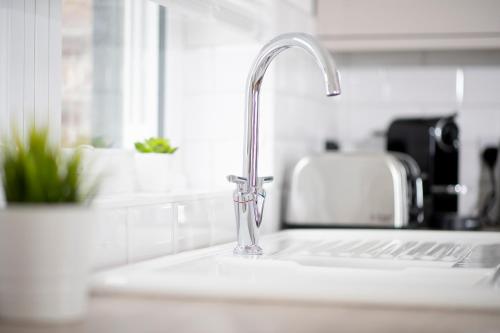 a kitchen sink with a chrome kitchen faucet at Flat B - Ground floor, 2 bedroom, 2 bathroom apartment with garden in Central Southsea, Portsmouth in Portsmouth
