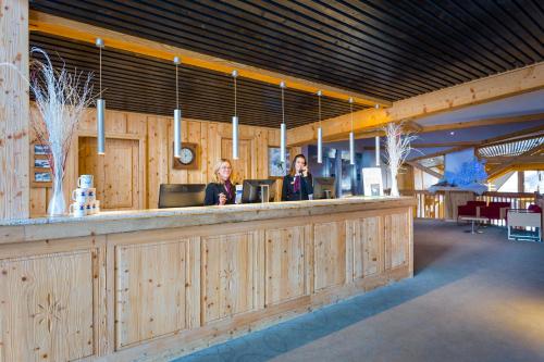 two women sitting at a bar in a restaurant at Hôtel Club mmv Les Arolles **** in Val Thorens