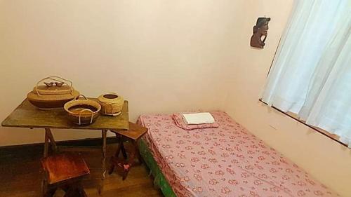 a small room with a table and a bed and a table with a tableablish at P&M Traveler's Inn in Banaue
