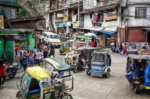 a busy street with cars and people in a city at P&M Traveler's Inn in Banaue