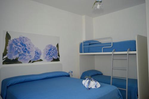 una camera con un letto blu e un letto a castello di Ica house a Castellammare di Stabia