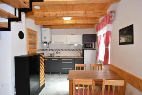 uma cozinha com uma mesa de madeira e cadeiras num quarto em Rekreačna usadlosť Pieninka em Lesnica