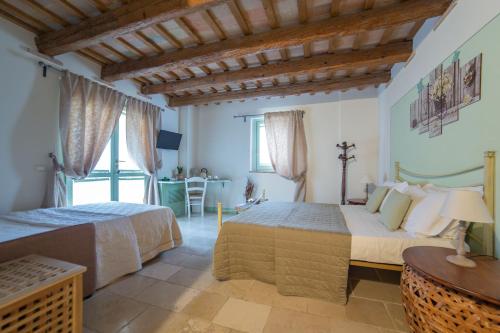 a bedroom with two beds and a table at Le Maraclà Country House in Iesi