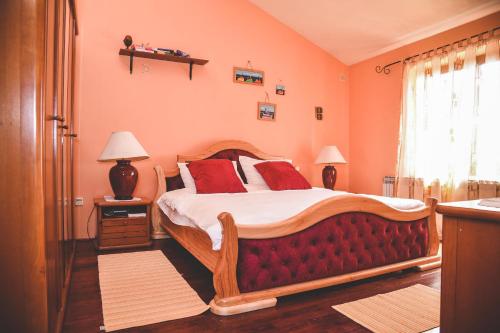 um quarto com uma cama grande e almofadas vermelhas em Apartment and Room Tacy em Opatija
